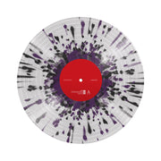 Clear vinyl record against a white background, with black and purple splatters, with a red label in the center. 