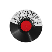 Picture of a vinyl record. It is half clear with black splatter, half black.