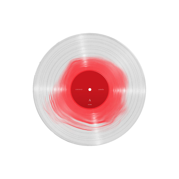 A clear vinyl record with red towards the center. The label in the center is red.