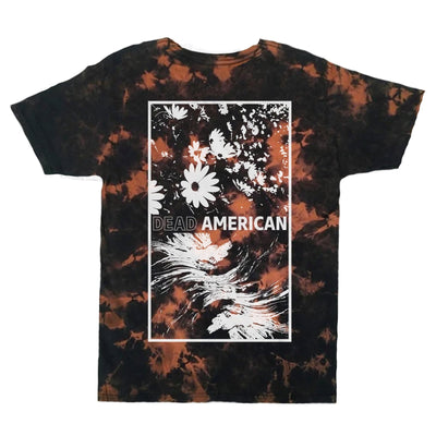 Black with bleach wash short sleeve shirt with a vertical white rectangle in the center. Inside the rectangle is text that says DEAD AMERICAN. On top of the text, there is a white floral design and below it is a wave design.