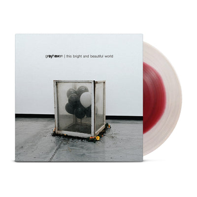 Black and white vinyl jacket with balloons in a glass box, surrounded by dirt and flowers. The box is on a concrete floor with a white wall. In the top center of the jacket "greyhaven, the bright and beautiful world" is written. Peeking out from the jacket is a white and red colored vinyl disc.