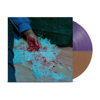 This LP cover is a picture of a persons arm laying on the floor.  The hand is bloody, and the hand is laying on a pile of white fur with blood stains.  There's a black couch in the background and there's a wood floor.  The vinyl is Purple on one half and Orange on the other half.