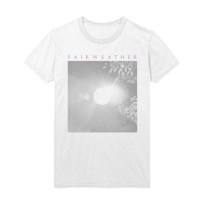 Image of Fairweather white t-shirt laid flat on white background. shirt has image of a moon through tree branches. "Fairweather" printed near collar in pink text. 