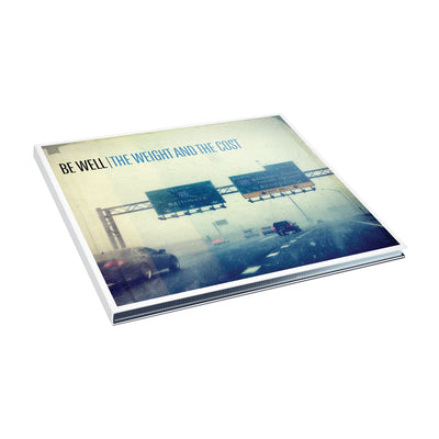 Square CD with black text in the top left that says BE WELL. Next to that there is blue text that says THE WEIGHT AND THE COST. The album artwork is an image of a foggy highway with cars driving and signs above the road. 