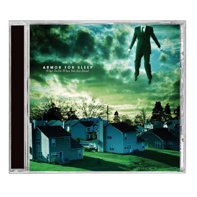 Square CD with white text that says ARMOR FOR SLEEP in blue and green tinted clouds. Below that there is smaller text that says WHAT TO DO WHEN YOU ARE DEAD. The album art is an image of a neighborhood of houses. In the top right there is a body of a man wearing a suit, but his head is not in the frame.
