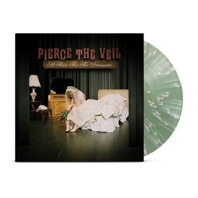 Pierce the Veil - 'A Flair For the Dramatic.' A vinyl record against a white background. The cover of the record is dark green. On top of the cover are the words "PIERCE THE VEIL" in dark red, appearing as though they're hanging on strings. The words "A Flair For The Dramatic" are below them in white. The cover is a photograph of a woman in a wedding dress on a stage, looking dejected with prop furniture and green curtains behind her. The vinyl record next to the cover is coke bottle green with creme dots.