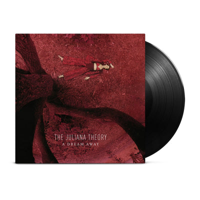 Black vinyl record coming out of vinyl jacket. Art on vinyl jacket is a girl laying on red ground next to the trunk of a tree. Photo is taken in an aerial above view. Text at the bottom of the vinyl jacket says THE JULIANA THEORY A DREAM AWAY