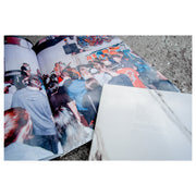 Image is the photo book opened to one of the pages, the picture is young culture during a performance taken from the back of the crowd. Their CD (this is) heaven is laying on top of the photo book, both laying on top of asphalt.