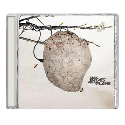 Sky Eats Airplane - 'S/T' CD. Pictured is a cream colored CD against a white background. On the cover of the CD is a tan-colored wasp's nest, with two wasps around it. Above the nest are tree branches, with electrical wires wrapped around them. One of the wires is plugged into the nest. In the bottom right corner are the words "SKY EATS AIRPLANE" in dark gray.