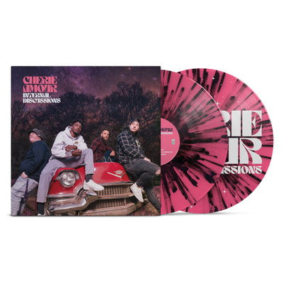 We see a vinyl cover with a picture of the band members sitting on an old 50s Cadillac. It is nighttime in the middle of winter and the stars are visible behind the band. In the top left corner there is text that reads Cherie Amour Internal Discussions. Sticking out of the vinyl cover is two vinyl's both colored pink and black.