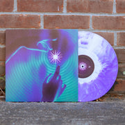 Vinyl jacket with a drawing of two hands reaching for a star. Around the star and covering the whole album cover is a ripple effect drawn in purple and green. Peeking out of the vinyl jacket is a clear and purple vinyl.