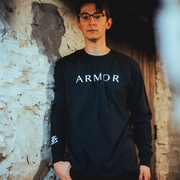 Someone wearing this long sleeve shirt is black.  The front of this shirt reads ARMOR in white letters.   On the right side of the shirt reads ARMOR FOR SLEEP in white letters going down the left side of the shirt.
