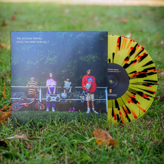 Vinyl jacket with an image of four kids leaning against a railing and holding helmets, skateboards, bikes, and a boombox. There is small text in the top left corner that says THE JULIANA THEORY. Under that there is yellow text that says STILL THE SAME KIDS PT. 1. Peeking out of the side is a yellow, red, and black vinyl.