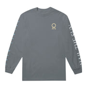 Asphalt colored long sleeve shirt with the Hail The Sun logo in the top corner. Along one sleeve there is white text that says HAIL THE SUN, and down the other is blue text that says SECRET WARS.
