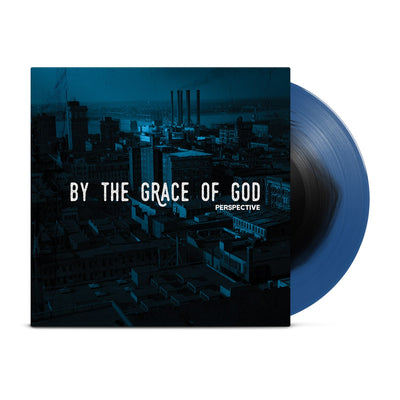 Vinyl jacket with large white text that says BY THE GRACE OF GOD across the center with smaller text below that says PERSPECTIVE. Album artwork is an image of buildings with a dark blue filter over it. peeking out of the jacket is a black and blue colored vinyl.