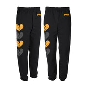 Black sweat pants with yellow and gray broken hearts running down the side of them.  There is text on the other side by the waistband that reads Kaonash.