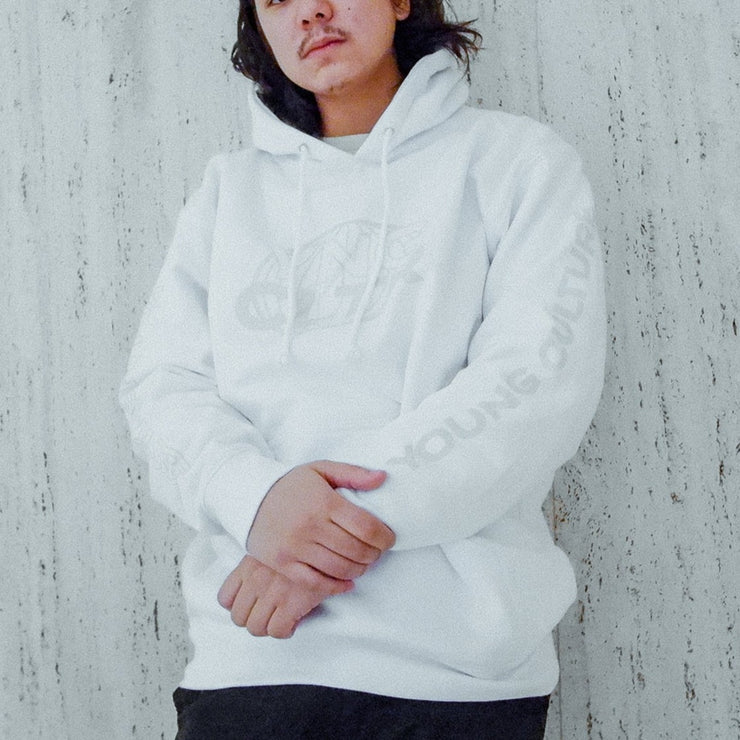 White pullover hoodie with "YNG CLTR" written on the chest in grey lettering, inside a grey globe. "YOUNG CULTURE" is written vertically along either arm in grey font. An individual is wearing the hoodie and leaning against a white wall.