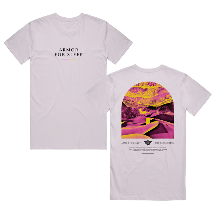 Lavender dust colored short sleeve shirt with ARMOR FOR SLEEP written across the chest in black font with a pink and yellow gradient line below it. The back of the shirt is artwork of a desert shaded in yellow and pink. Below the artwork there is text that says ARMOR FOR SLEEP and THE RAIN MUSEUM.